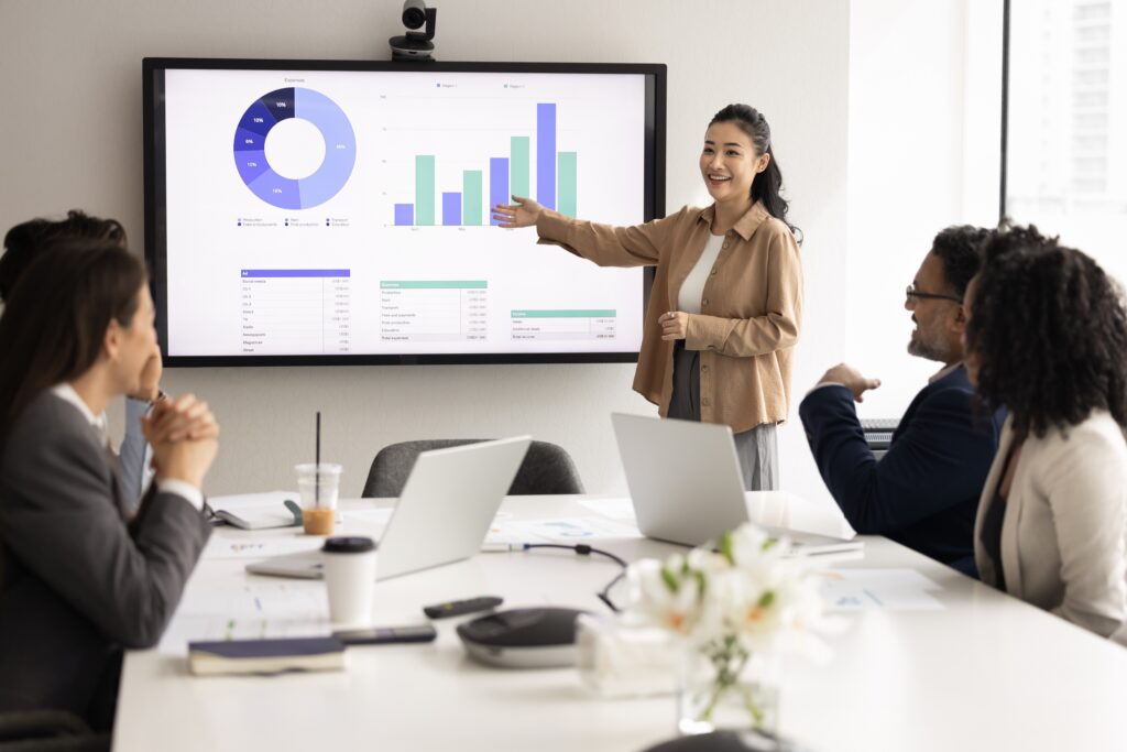 Young business professional leading a discussion in a meeting with senior colleagues