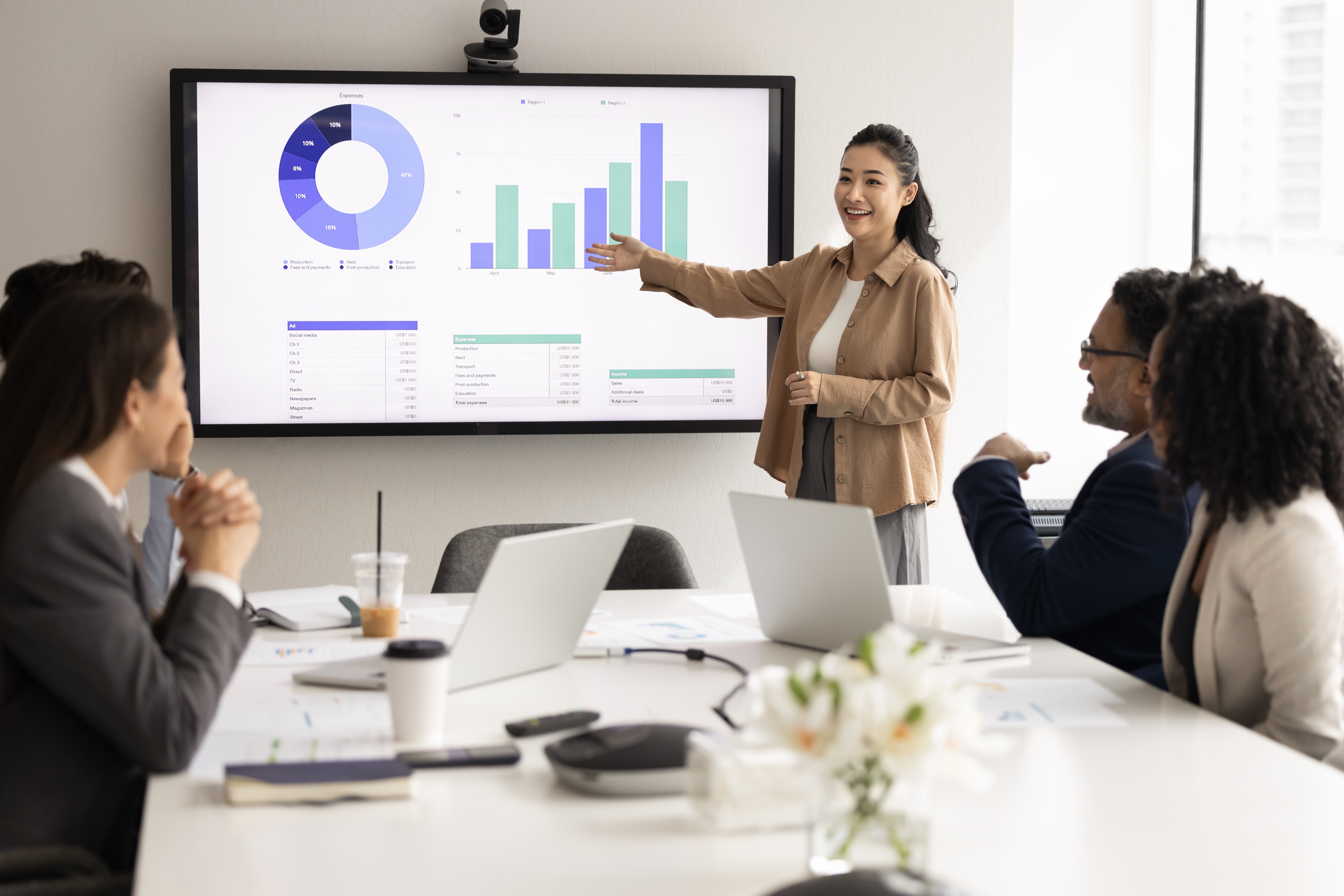 Young business professional leading a discussion in a meeting with senior colleagues