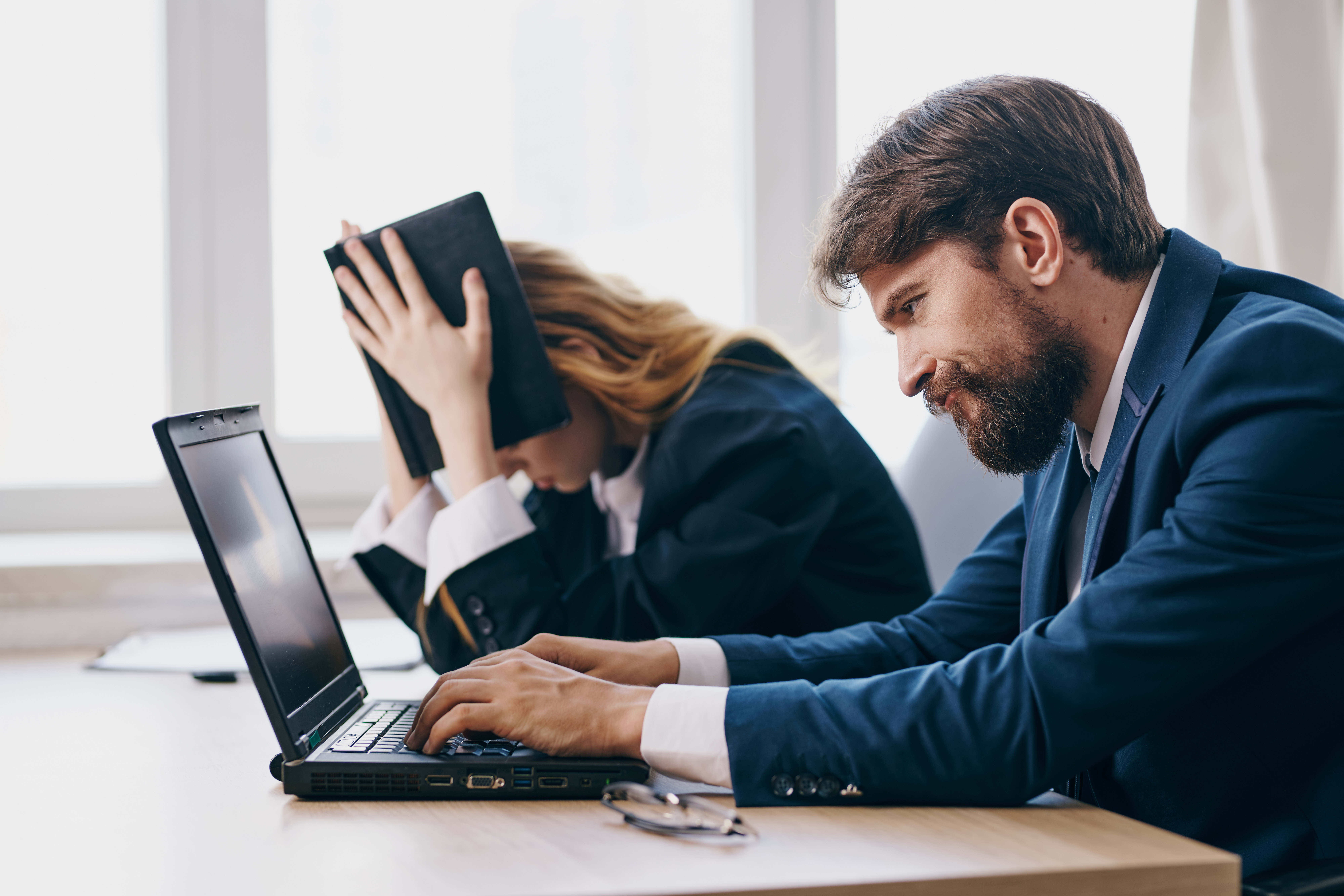 Two business professionals looking stressed at work.
